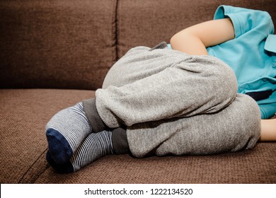 A Little Boy, Child Is Lying On The Bed And Holding His Belly. Baby's Medication And Health Concept. Stomach Ache. Suffering A Young Child. Food Poisoning, Abdominal Pain. Health Problems In Children.