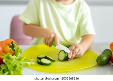 Little Boy Child Sitting At The Table With Vegetables In The Kitchen At Home, Cutting Vegetables For Salad, Baby Smiling, Healthy Eating Concept, Vegetarian