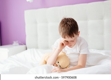 Little Boy Child Waking Up At The Morning. Hugging His Favourite Teddy Bear