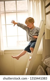 Little Boy Climbing Down His Bunk Bed Ladder