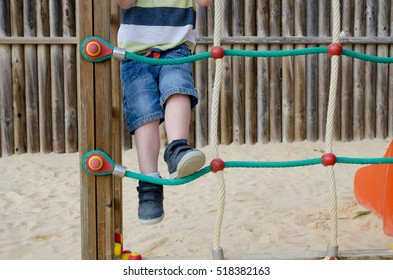 Little Boy Climbing On A Climbing Frame