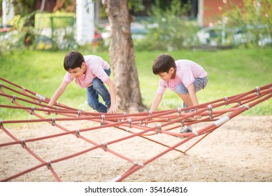 Little Boy Climbing On The Rope At Playground