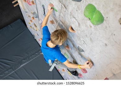 Little Boy Climbing A Rock Wall Indoor