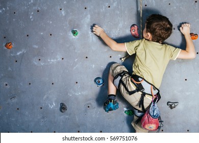 little boy climbing a rock wall indoor. Concept of sport life. - Powered by Shutterstock