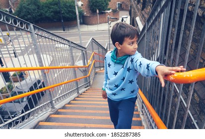 A Little Boy Climbing Up The Stairs