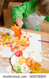 Little boy colors the autumn leaves and paint  Montessori concept  early education  Easy ideas to do at home 