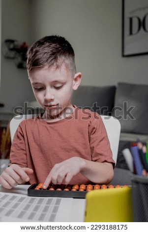 Little boy Counting with help an abacus. Mental arithmetic, brain development.