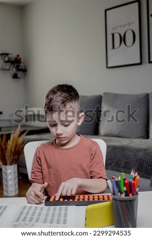 Little boy Counting with help an abacus. Mental arithmetic, brain development.