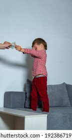 Little Boy Covered His Eyes With His Hand And Gives Money To A Stranger. Little Boy Stealing Money From Parents.