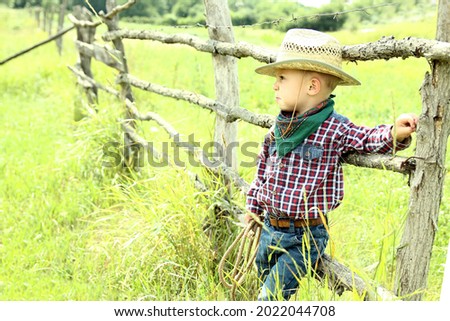 a little boy cowboy in hat on nature