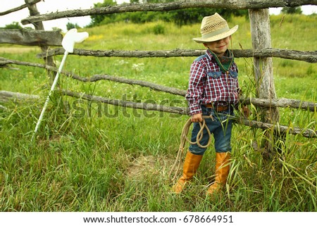 a little boy cowboy on nature