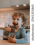 little boy with curly hair eats cocoa for Christmas