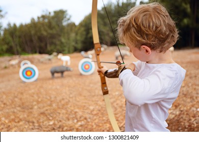 little boy doing archery, aiming at the target, fun outdoor activity concept