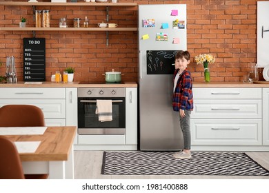 Little Boy Drawing On Chalkboard In Kitchen