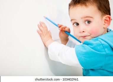 Little Boy Drawing On A White Wall