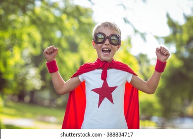 Little Boy Dressed As Superman In The Garden