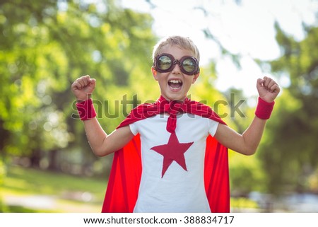 Little boy dressed as superman in the garden