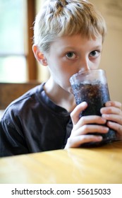 Little Boy Drinking A Glass Of Soda