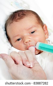 little boy drinking milk from the mother of the syringe