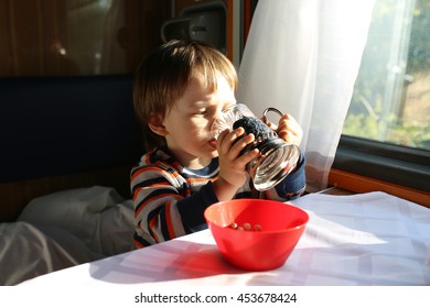 Little Boy Drinks Tea In Speeding Train