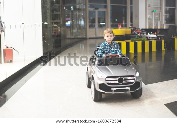 Little boy driving a\
electric toy car
