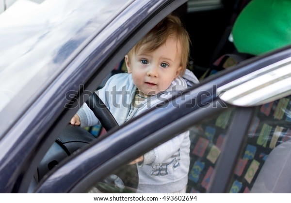  little boy driving\
fathers car