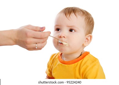 Little Boy Eating Baby Food With Spoon. Isolated On White Background