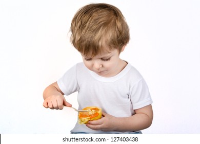 Little Boy  Eating Cheesecake Muffin. Isolated On White Background.