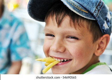 Little Boy Eating French Fries In Cafe