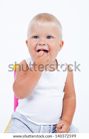 Similar – Happy adorable infant baby boy child smiling while eating two frozen fruit popsicle ice creams in simmer.