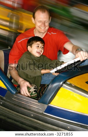 A little boy enjoying a bumper car ride with his father at the steam fair, showing movement in the background. Focus on laughing child. Stock photo © 