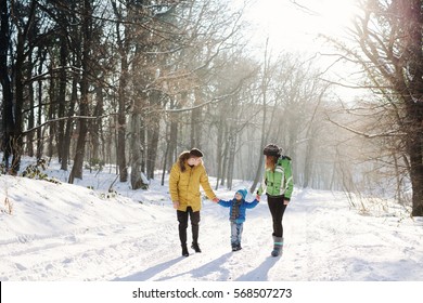 Little Boy Enjoying A Sleigh Ride. Child Sledding With Young Mom And Dad. Toddler Kid Riding A Sledge. Children Play Outdoors In Snow. Kids Sled In Winter Park. Outdoor Active Fun For Family Vacation.