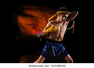 Little Boy Exercising Thai Boxing On Black Background. Mixed Light. Fighter Practicing In Martial Arts In Action, Motion. Evolution Of Movement, Catching Moment. Youth, Sport, Asian Culture Concept.