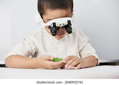 A Little Boy Exploring Slime Structure With Head Magnifying Glasses Headset