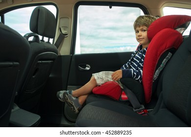 Little Boy Fasten Seat Belt In High Back Booster Car Seat. Child Safety.