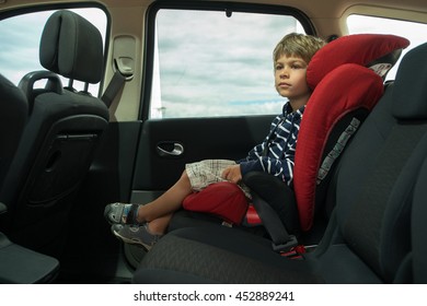 Little Boy Fasten Seat Belt In High Back Booster Car Seat. Child Safety.