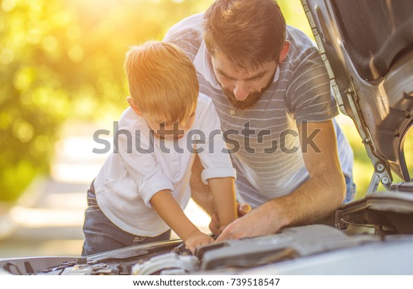 The little boy and\
the father fixing a car