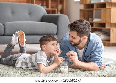 Little Boy And Father With Savings For Education At Home