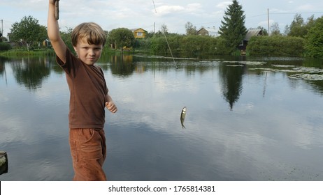 A Little Boy Fisherman Caught Small Fish From The Pond