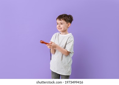 Little Boy With Flashlight On Color Background