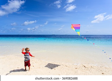 Little Boy Flying A Kite On Tropical Beach