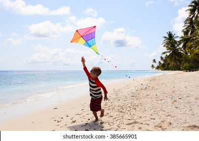 Little Boy Flying A Kite On Tropical Beach
