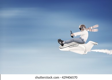 Little boy flying on the sky while driving a small airplane and wearing helmet