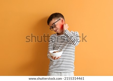 Little boy with food allergy on orange background