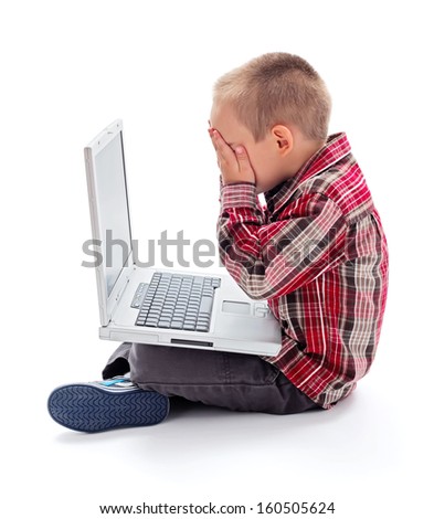 Little boy in front of laptop hiding his face