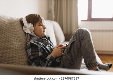 Little boy with gamepad playing video game at home - Powered by Shutterstock