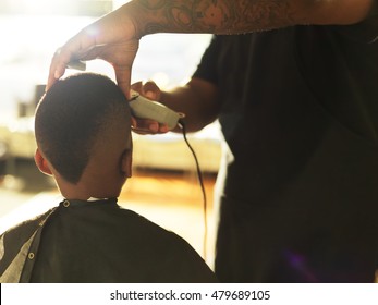 Little Boy Getting Hair Cut By Barber, Shot With Selective Focus And Lens Flare