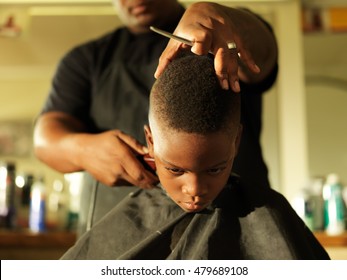 little boy getting hair cut by barber