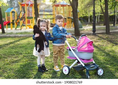 Little boy and little girl baby walk with a stroller for dolls. 