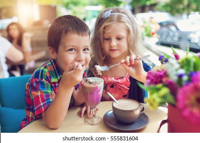 Little boy with a girl eating ice cream at an outdoor cafe in outdoor cafe